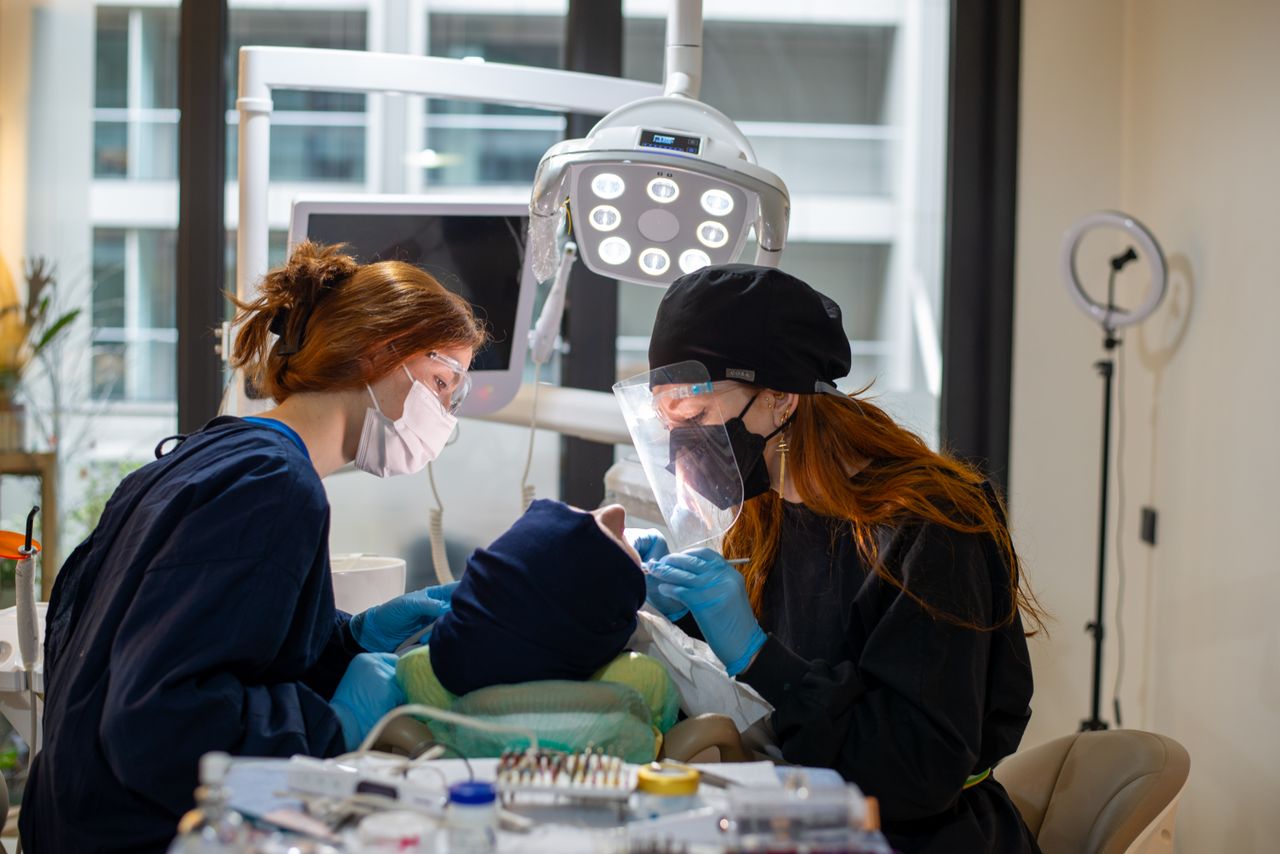 Dentists performing a procedure in a modern clinic with advanced equipment.